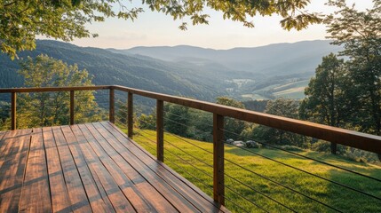 Wooden deck with railing overlooking valley landscape at sunset.