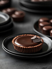 Elegant chocolate tart on dark plates with glossy finish