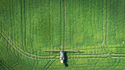 Tractor sprays fertilizer and water on a green fields of East Sussex, UK