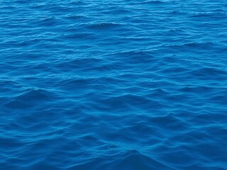 Smooth deep blue waves rippling on the surface of the sea, creating a mesmerizing texture, waves, surface