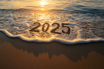 2025 written in sand with a gentle ocean wave washing over it