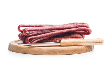 Smoked kabanos. Mini dried thin sausages on cutting board isolated on white background