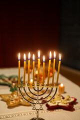 Fototapeta premium candles burning in menorah on festive table for Hanukkah