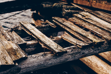 Old rusty nails sticking out of wooden collapsed bridge, structural repair