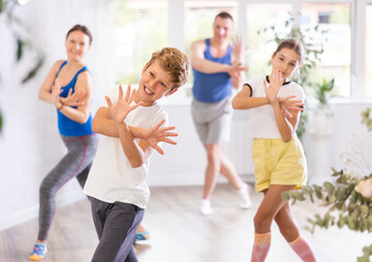 Obraz premium Parents together with their children learn how to dance salsa or boogie-woogie in a dance class
