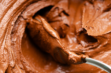 Close-up of a spoon in chocolate ice cream.