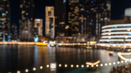 Burj Khalifa Lake at night, showcasing illuminated skyscrapers, reflecting pools, and the vibrant cityscape of Downtown Dubai. Blur and out of focus done intentionally