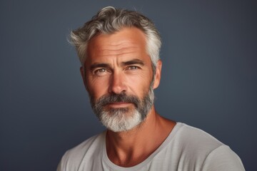 Fototapeta premium A man with a beard and gray hair is smiling at the camera