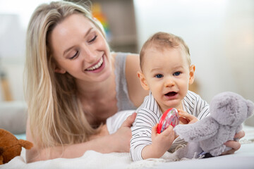 cute baby and mother sitting on floor at home