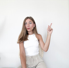 Young woman with long hair gives an instruction while sitting in a light room