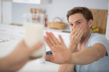 man refusing glass of milk