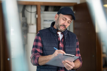 positive repairman standing with his clipboard