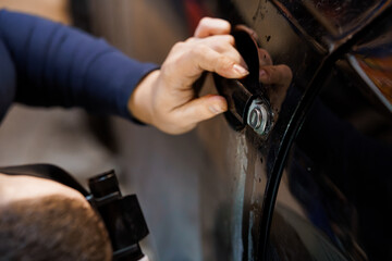 Automotive Repair: Close-Up of a Mechanic Working on a Car Door Handle