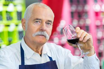 vendor holding a glass of wine