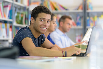 portrait of student using laptop in library