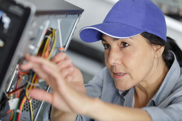 female technician unscrewing a back of a laptop