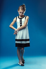 Shy girl looking down in a studio with blue background