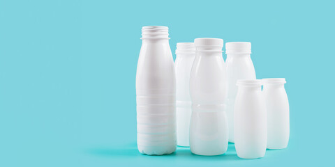 White plastic bottles displayed against a blue background, evoking a sense of environmental responsibility and the need for sustainable packaging solutions.