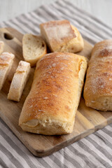 Homemade Sliced Ciabatta Bread on a wooden board, side view.