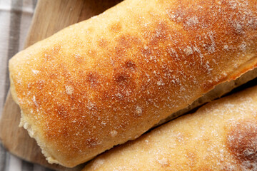 Homemade Sliced Ciabatta Bread on a wooden board, top view. Flat lay, overhead, from above. Close-up.