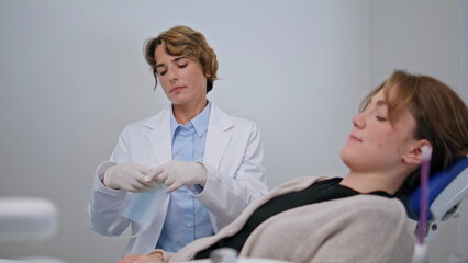 Obraz premium Woman sitting dental chair at treatment preparation closeup. Female dentist