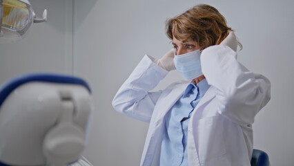 Woman orthodontist wearing mask for dental checkup patient in dentistry closeup.