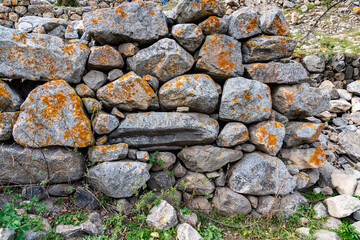 a wall made of ancient stones stacked in a wall exposed to external natural factors. copy space.