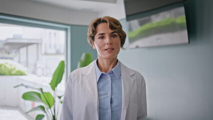 Fototapeta premium Woman doctor posing confidently in healthcare office closeup. Calm professional 