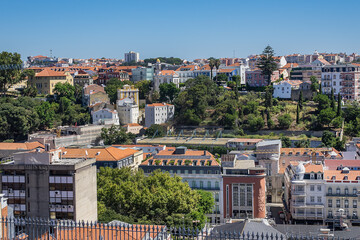 Fototapeta premium Panoramic view of Lisbon cityscape, showcasing terracotta rooftops, traditional and modern architecture under a clear blue sky. Lisbon, Portugal. 