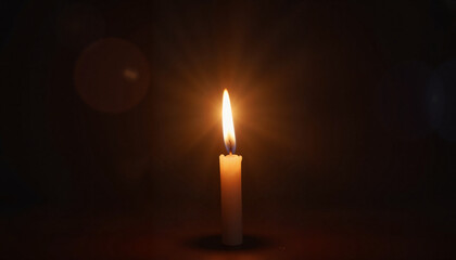 Burning candle in dark room creating warm glow.