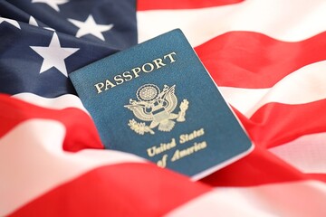 Fototapeta premium Latest version of United States of America citizen Passport on USA national flag