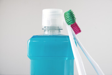 Bottle of mouthwash and plastic toothbrushes. Close up