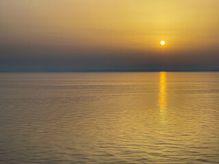 Adriatic Sea,, Italy - June 29, 2024: Sunset over the Adriatic Sea colors sky and sea yellow