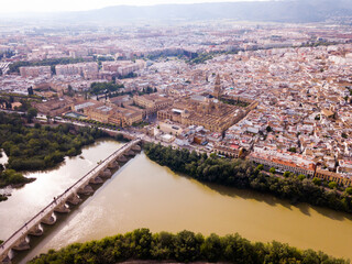 Aerial view of Historic centre of Cordoba with antique Roman Bridge over Guadalquivir river and medieval Mosque-Cathedral, Spain