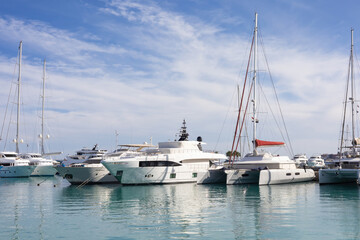 Obraz premium Scenic marina with luxury yachts and sailboats on a clear day