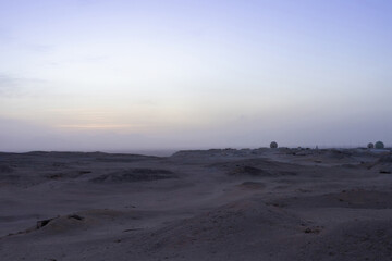 Tranquil desert landscape at dusk with expansive horizon and subtle colors