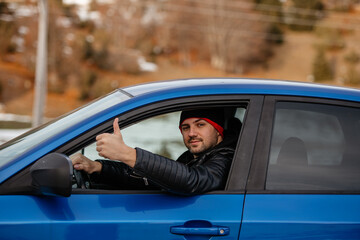 I Like Driving. Smiling caucasin guy sitting inside car and showing thumb up, approving his new vehicle smiling at camera. Happy European man driver renting auto for weekend trip. Young man doing thum