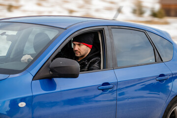 Another busy day. Handsome young man looking away while driving a status car