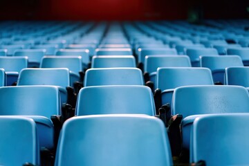 Obraz premium A beautifully symmetrical view of blue stadium seats conveying the essence of organized sports venues. The image stirs anticipation for lively sporting events.