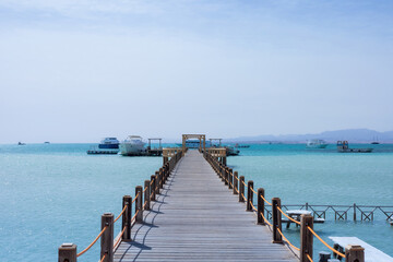 Obraz premium Serene seascape with wooden pier and boats on turquoise water