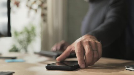 person receiving mail message on smart phone mobile,male employee working at the desk receives email notification on the smartphone