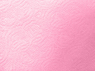 Close-up macro view of pink embossed kitchen paper towel texture details with circular patterns design. Soft textured absorbent material for households cleaning and wiping surfaces efficiently.