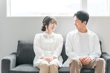 家のリビングのソファでくつろぐ夫婦・カップル・パートナー・家族
