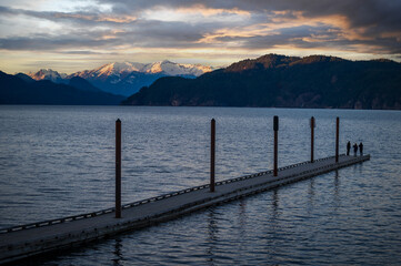 Boat dock at Harrison Hot Springs Resort with a view to Mount Breakenridge in the Lillooet Range. Sunset at this popular escape over Harrison Lake and the Canadian Rockies in the Fraser Valley.