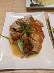 Roasted chicken pieces served with greens and light sauce.