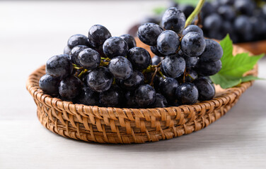 Black grapes in basket on white table, Seedless grapes