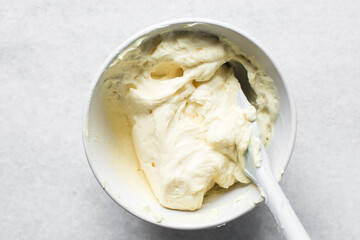 overhead view of smooth buttercream in a mixing bowl,Top view of cream buttercream in a white mixing bowl, silky smooth american buttercream in a ceramic bowl