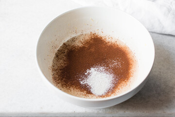Overhead view of flour being added to madeleine batter, mixing flour into batter, process of making cake or Madeleines