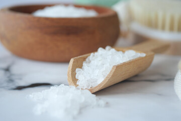 Natural Sea Salt Displayed in a Wooden Bowl with a Scoop on a Marble Surface