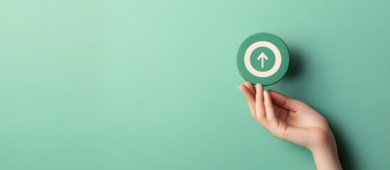 Hand holding green target icon on minimalist background, concept of focus, goal setting, achievement